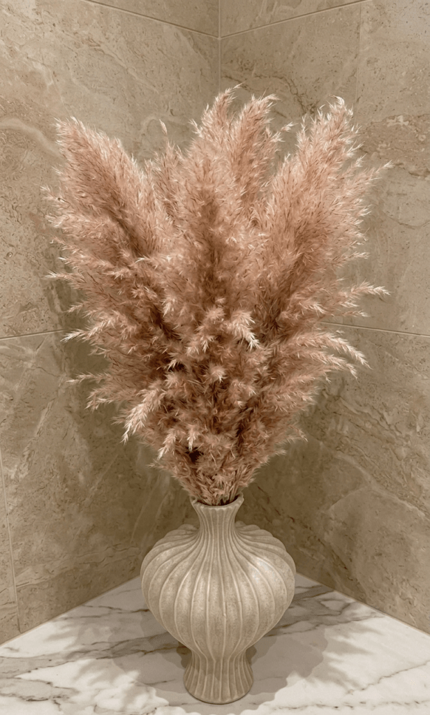 pampas grass in neutral ceramic vase adding warmth and soft texture to small bathroom decor