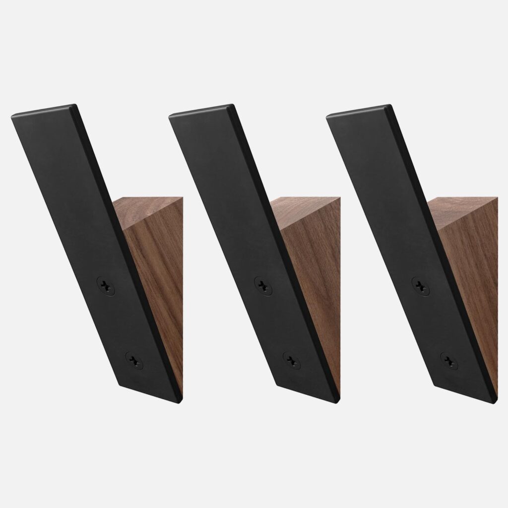 Minimal black wall hooks on a warm wood slat panel wall in a modern Japandi entryway