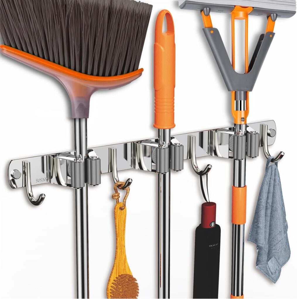 Wall-mounted broom and mop holder keeping cleaning tools off the floor in a small apartment kitchen or utility area