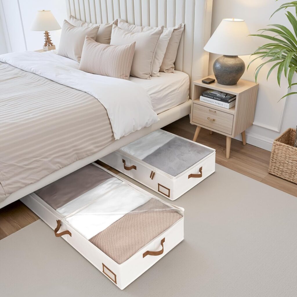 Stackable beige fabric storage bins with clear windows for organizing sweaters, bedding, and seasonal clothes in a small bedroom