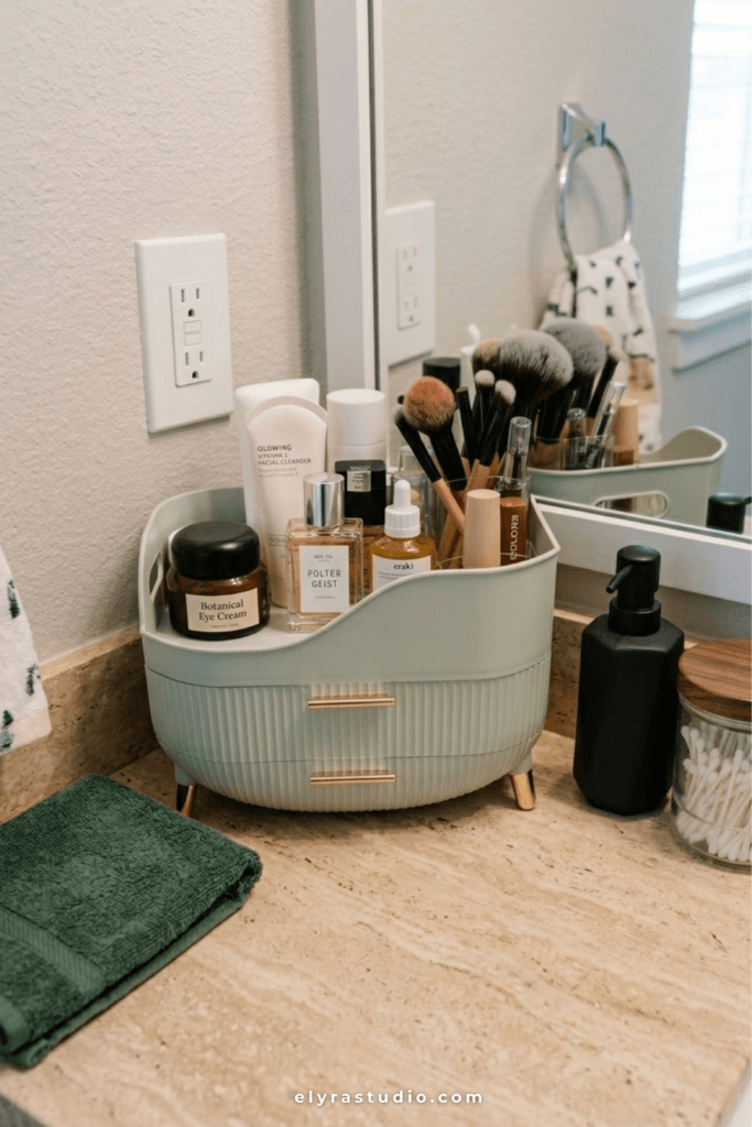 Organized small bathroom vanity with clear acrylic makeup storage and clutter-free marble countertop styling.