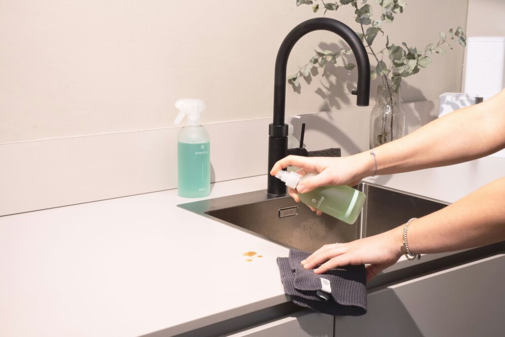 wiping kitchen sink during a simple evening home reset routine