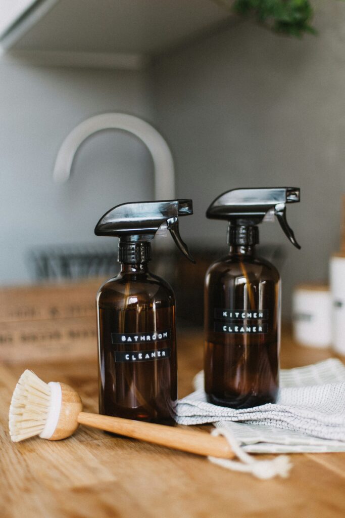 minimal neutral cleaning products styled on kitchen counter with cozy home aesthetic