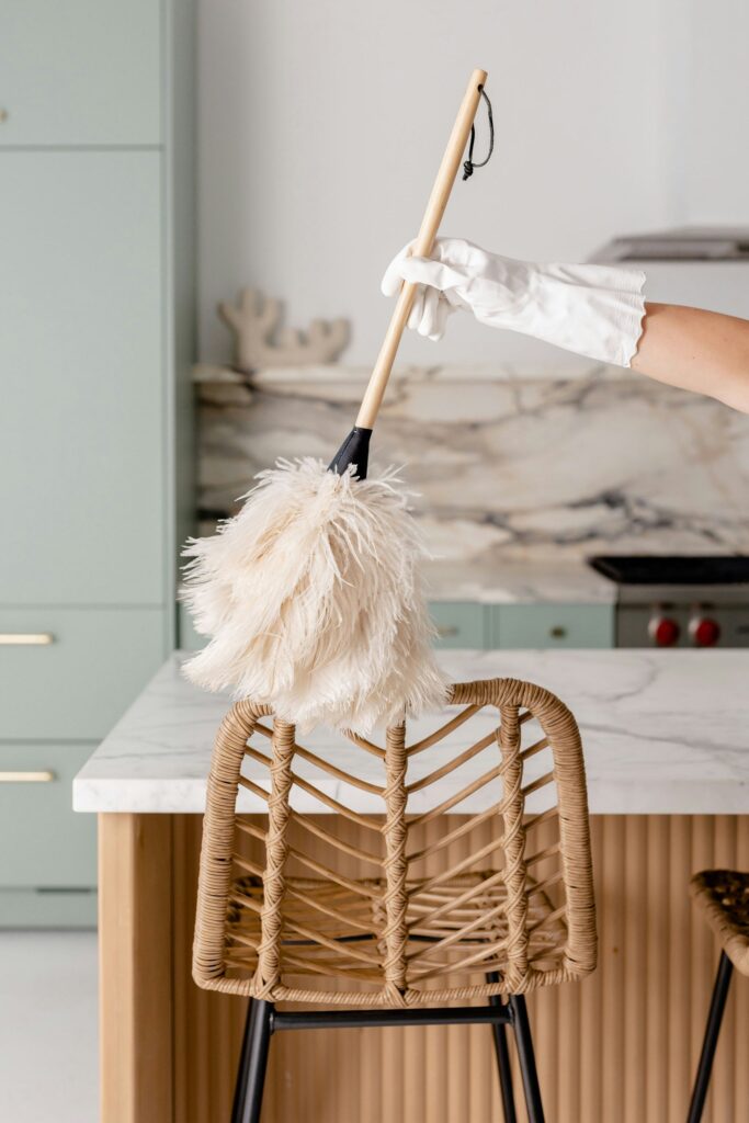 soft feather duster in bright neutral kitchen showing light everyday cleaning routine