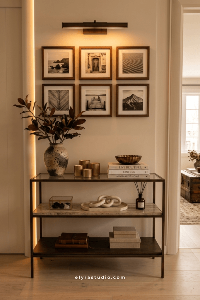 Grid gallery wall with framed artwork, picture light, and modern console table in a stylish hallway.